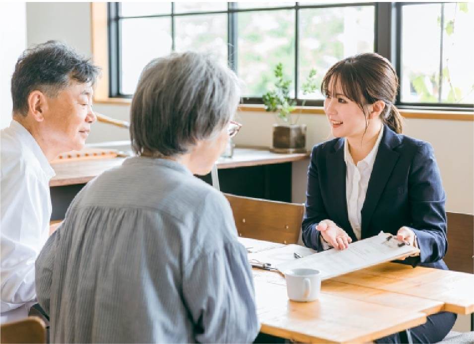 夫婦がスーツを着た女性から説明を受けている